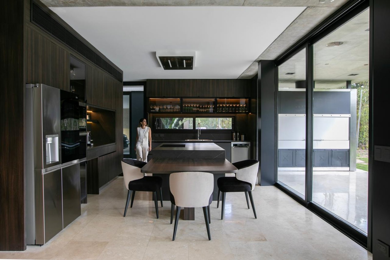 Cozinha moderna com ilha de pedra e armários em madeira escura — projeto Infinito - Estudio Made it, por ABEJA CONCEPT, em Chubut 415
